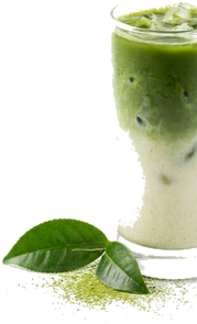 Iced matcha latte in a tall glass with fresh matcha and tea leaves